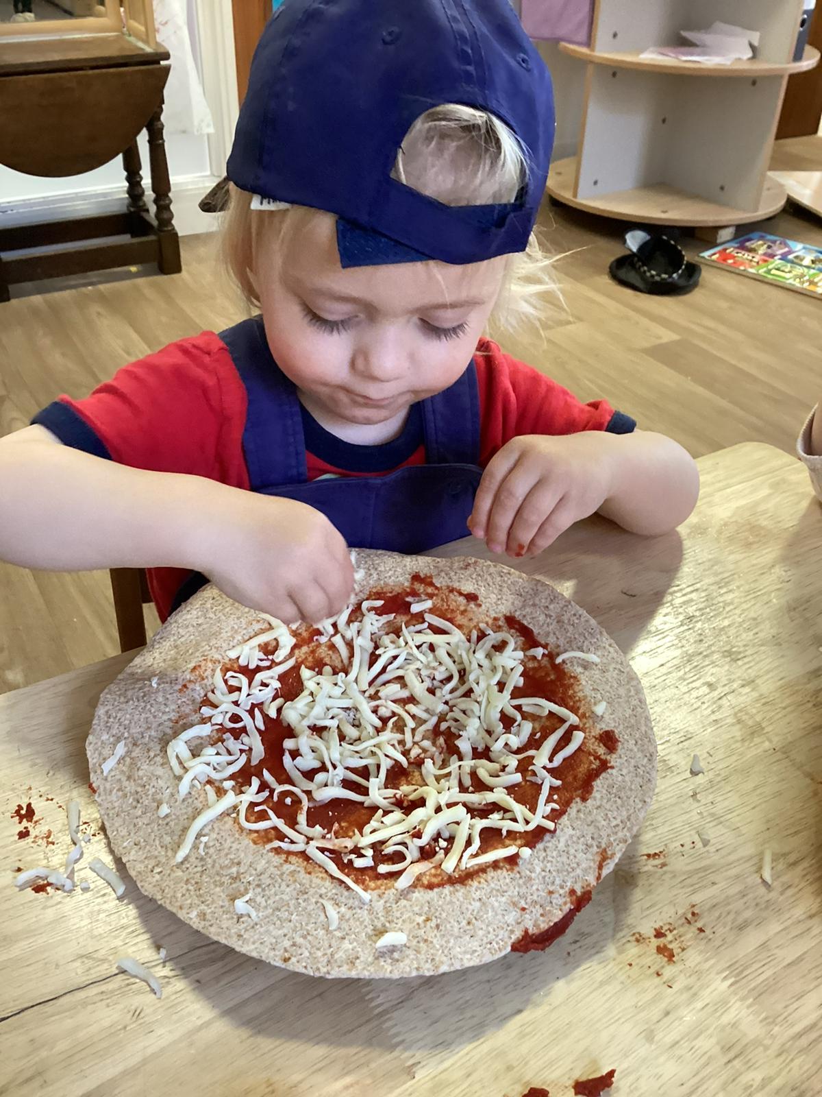 Children making pizzas in a cooking activity at Wibli Wobli Welsh nursery Cardiff